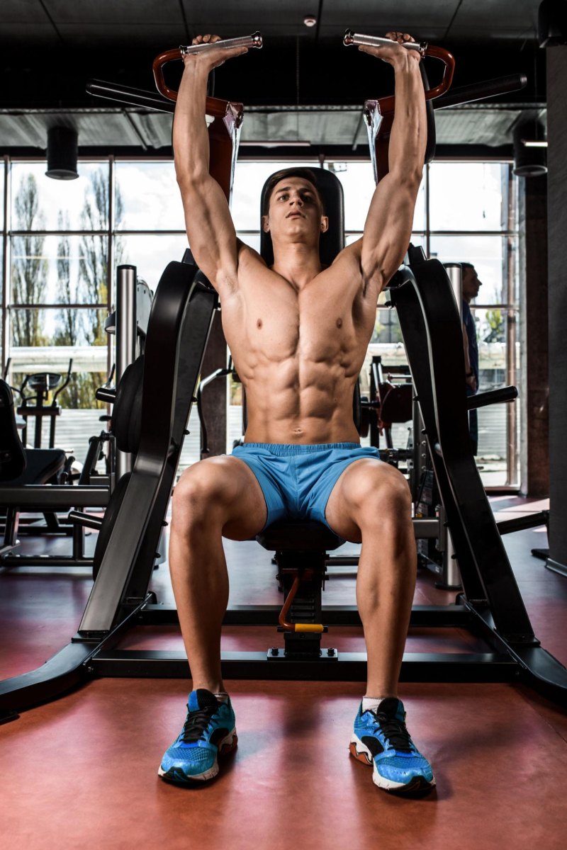 Man exercising in gym with athletic build