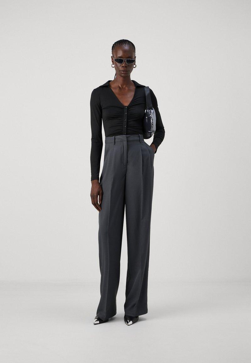 Tall model wearing high waist trousers