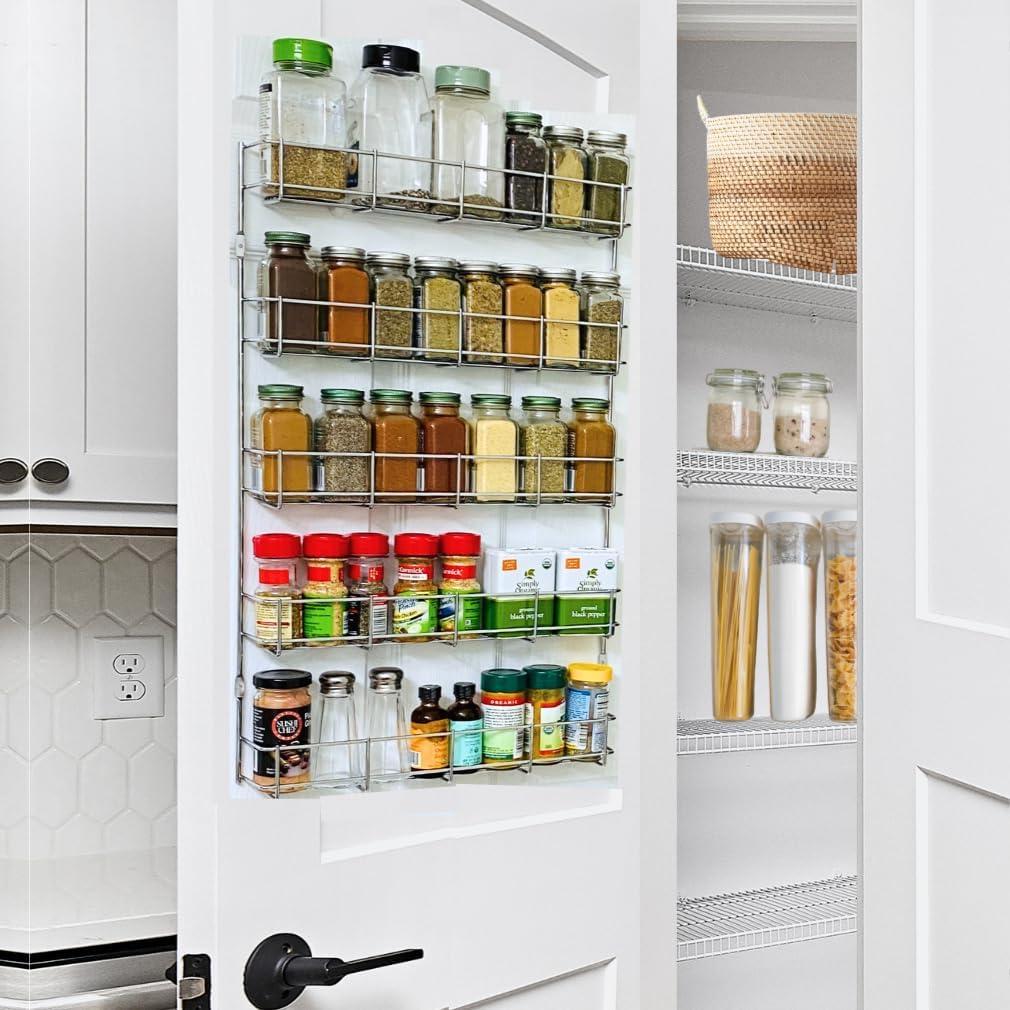 Spice jars organized on the back of a pantry door