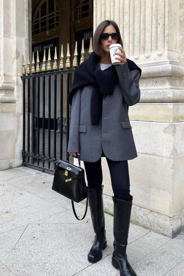 Model wearing knee high boots and fall layers