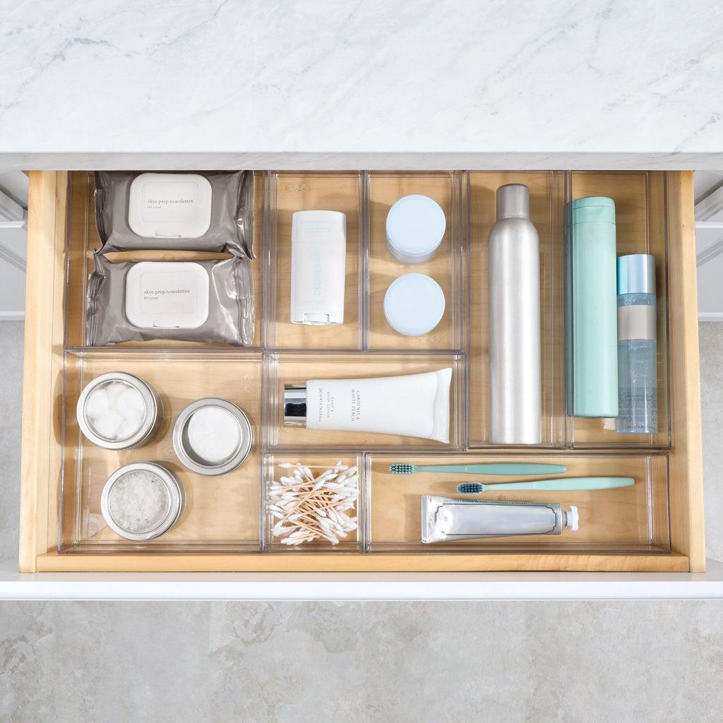 Shallow bathroom drawer with slim low-profile trays holding small toiletries
