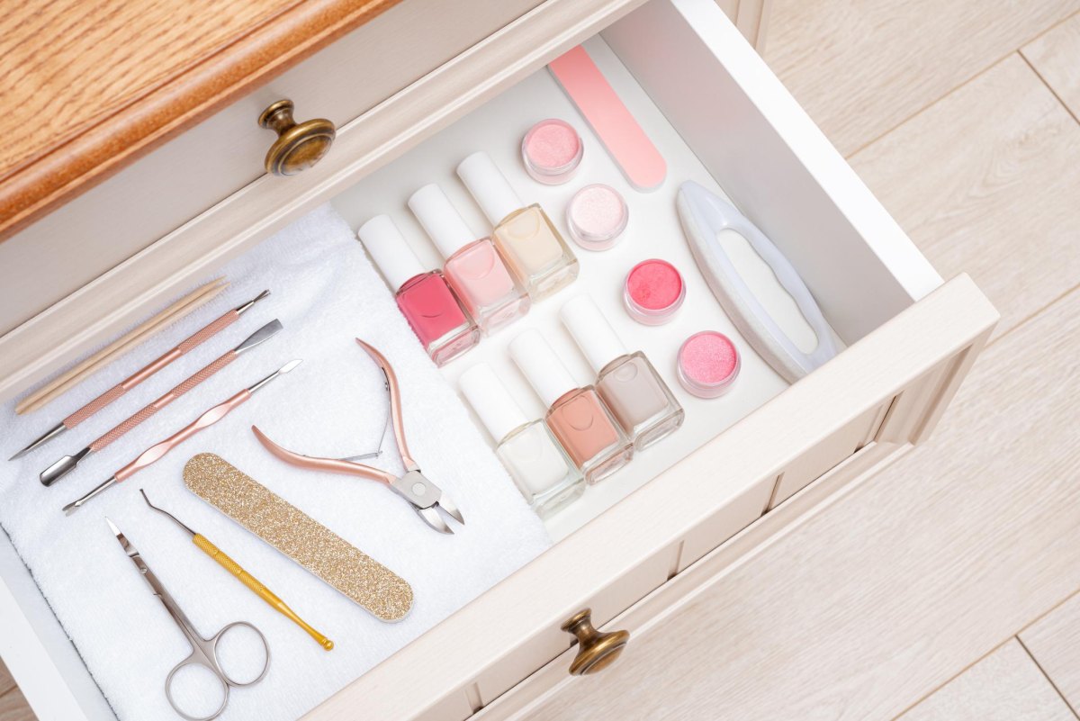 Nail polish bottles clippers files and manicure tools arranged in divided trays