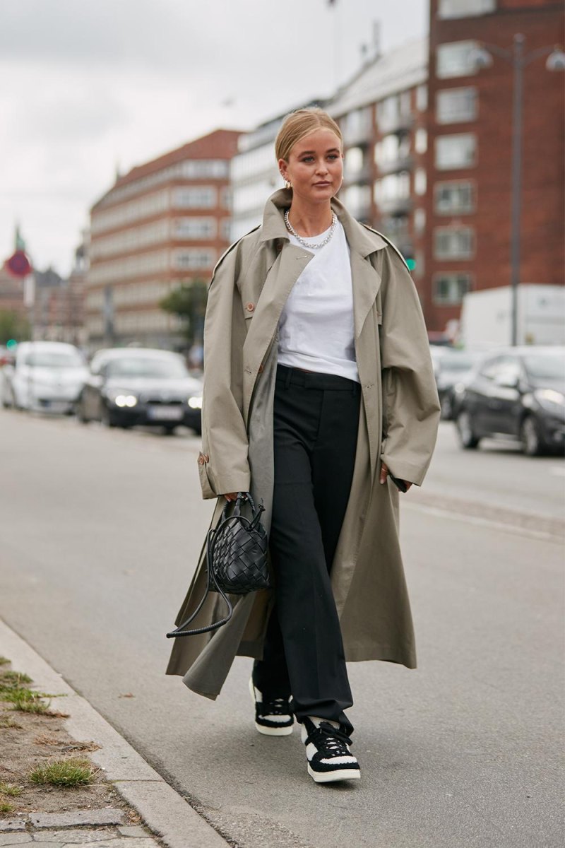 Model wearing trench coat with streetwear layers