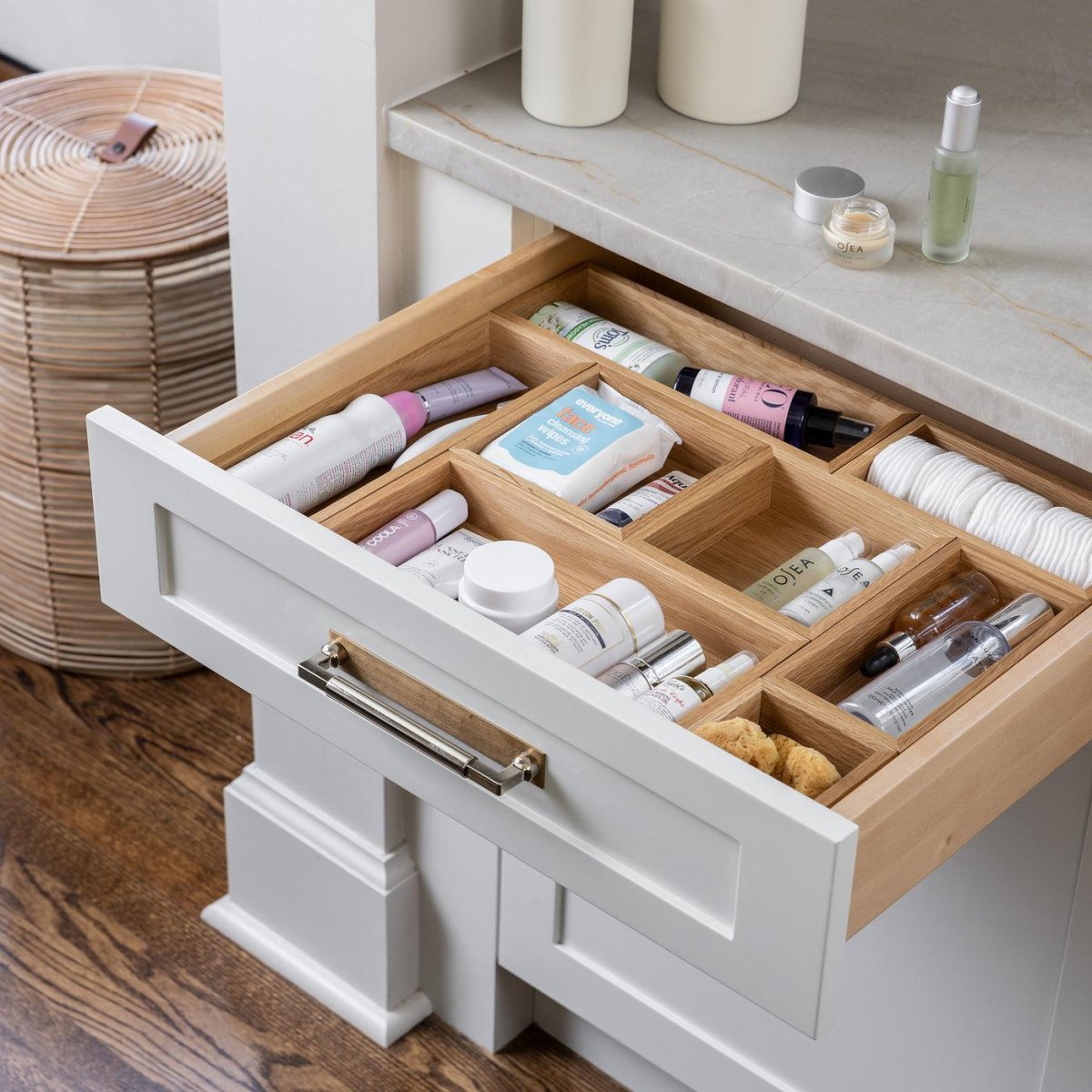 Natural bamboo bathroom drawer organizer holding neatly separated toiletries